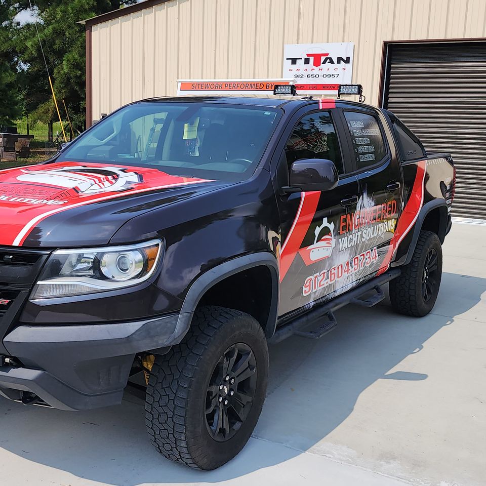 Red and black commercial wrap on a work pickup outside Titan Graphix